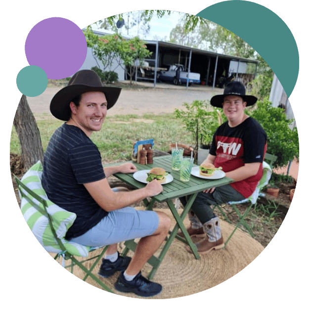 Two men smiling while having burger