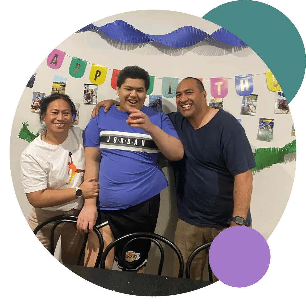 A disabled man smiling with his support workers