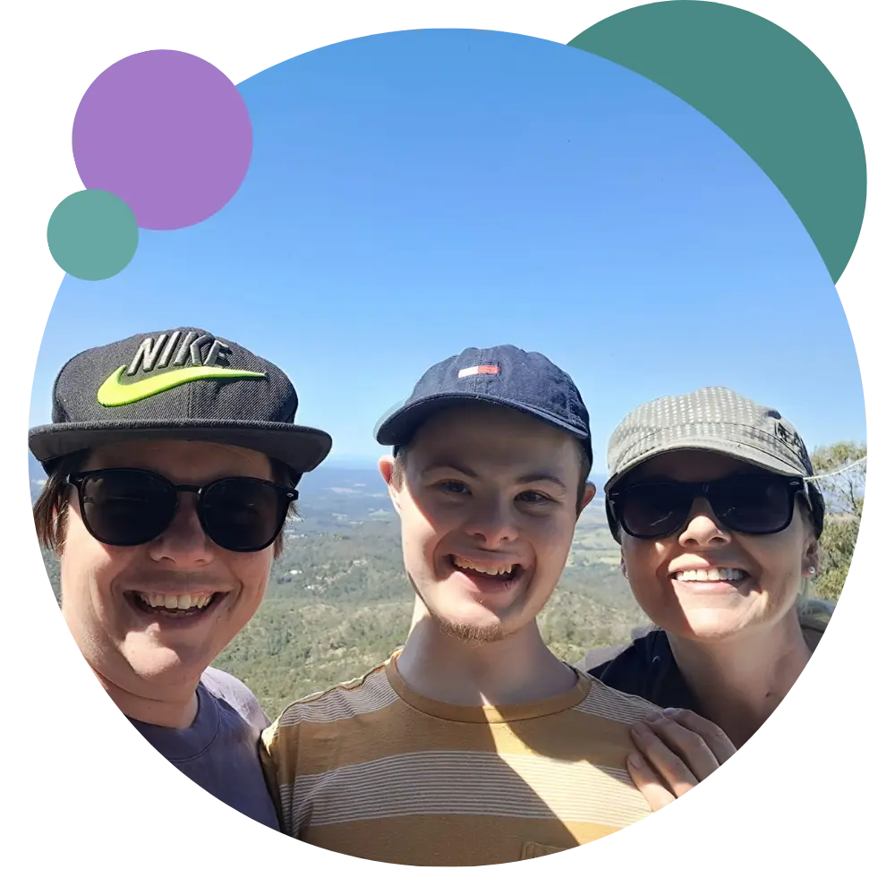 A disabled man and his support workers smiling